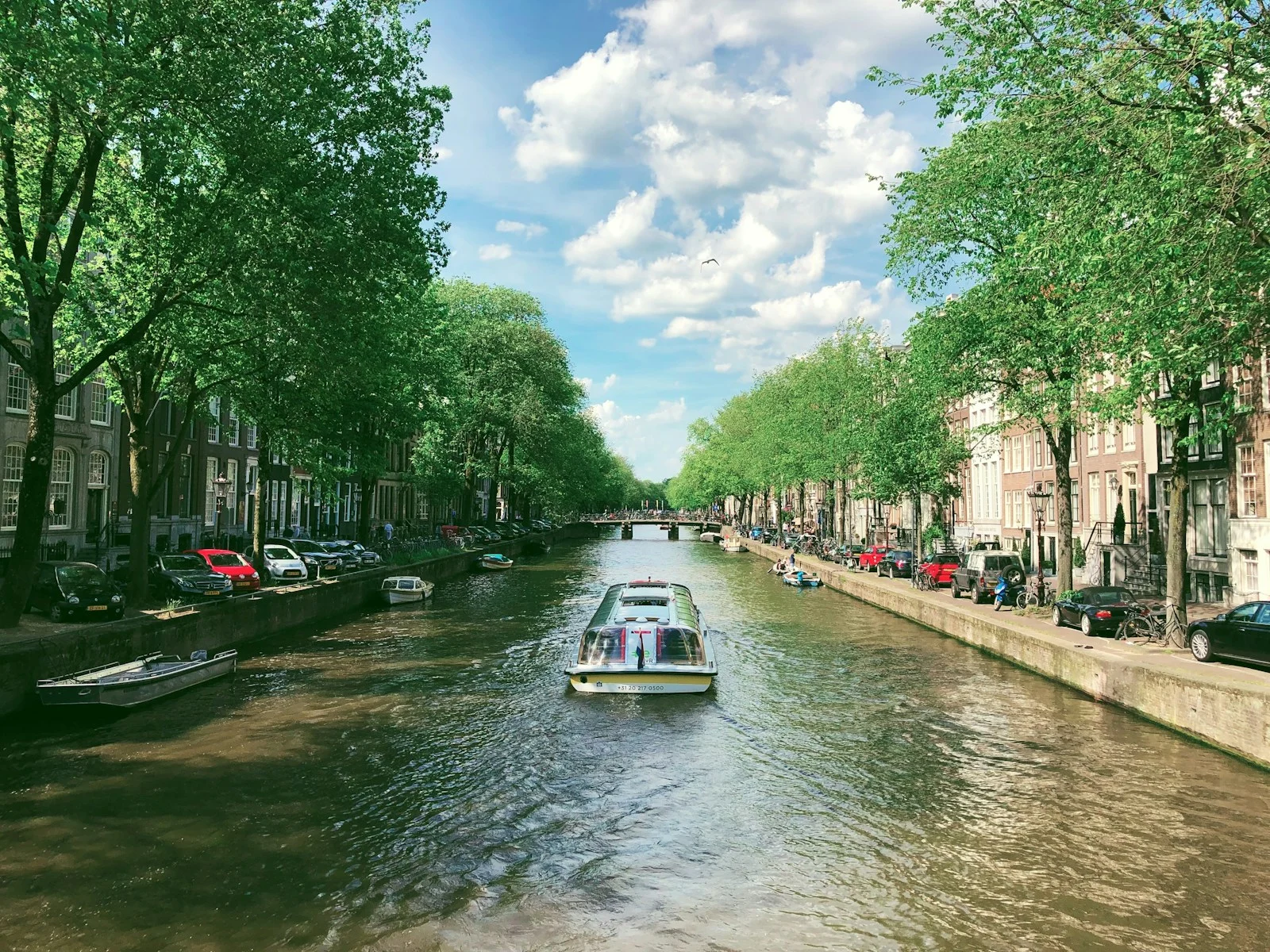 a boat traveling down a river next to tall buildings