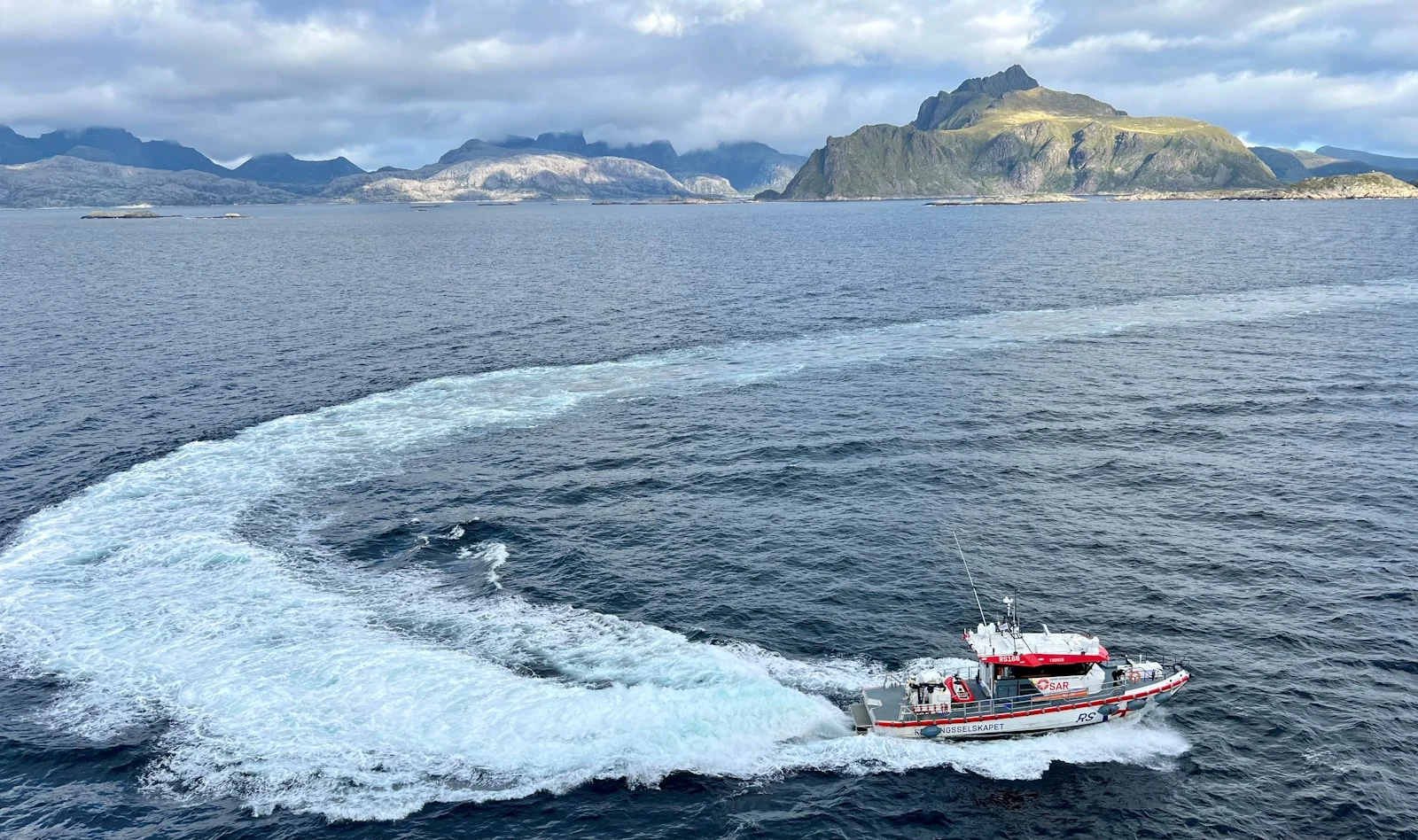 A small boat traveling across a large body of water