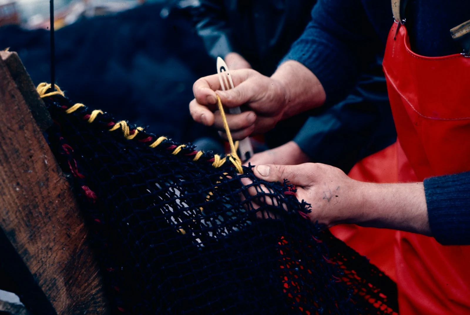 Two people working on a piece of fabric